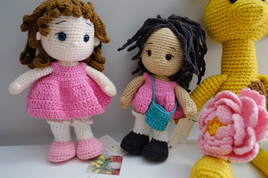 Black hair doll in pink dress with turquoise purse