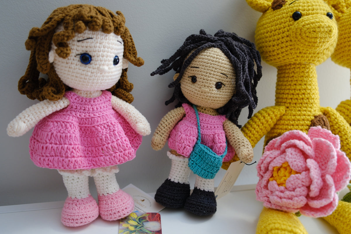 Black hair doll in pink dress with turquoise purse