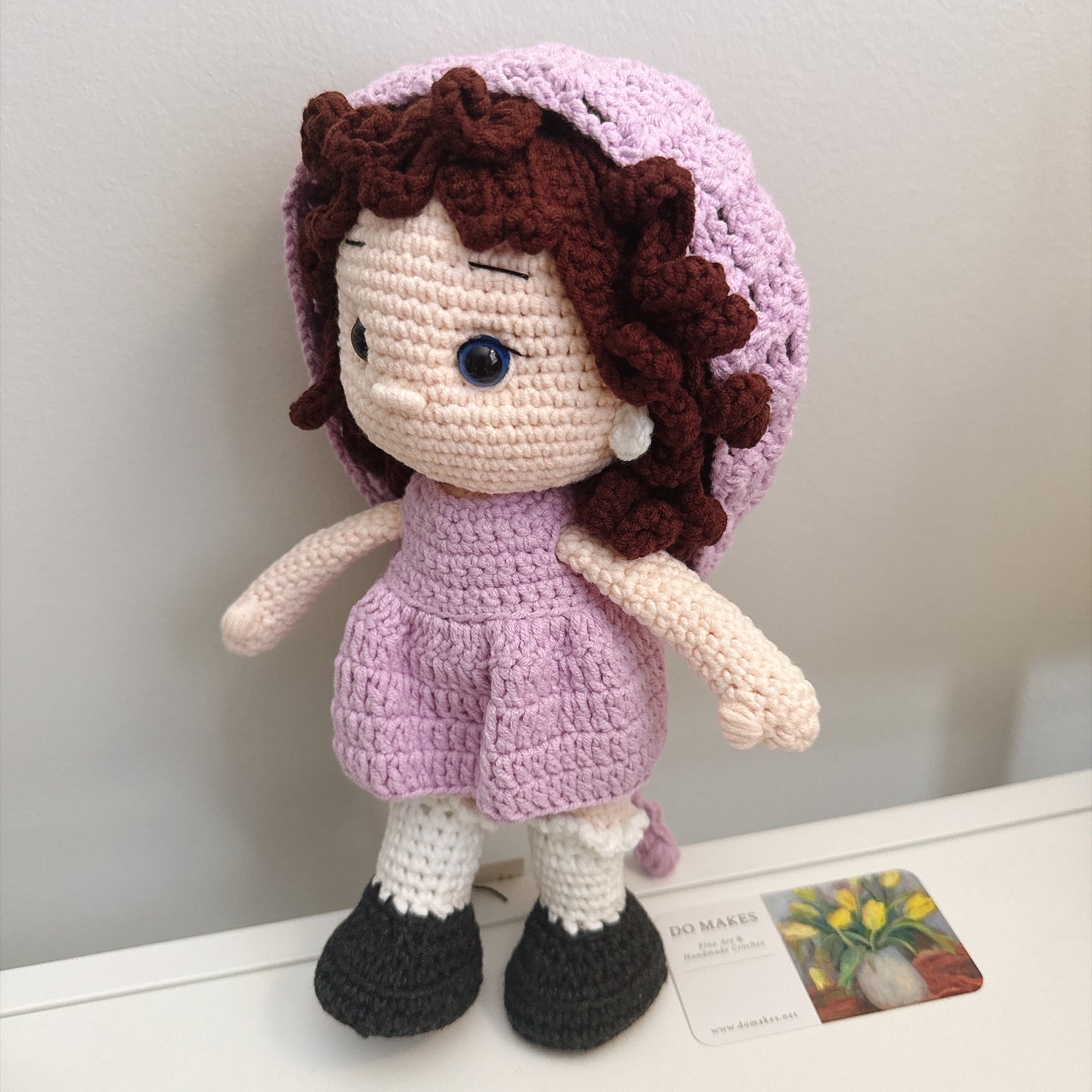Brown hair doll in purple dress & hat