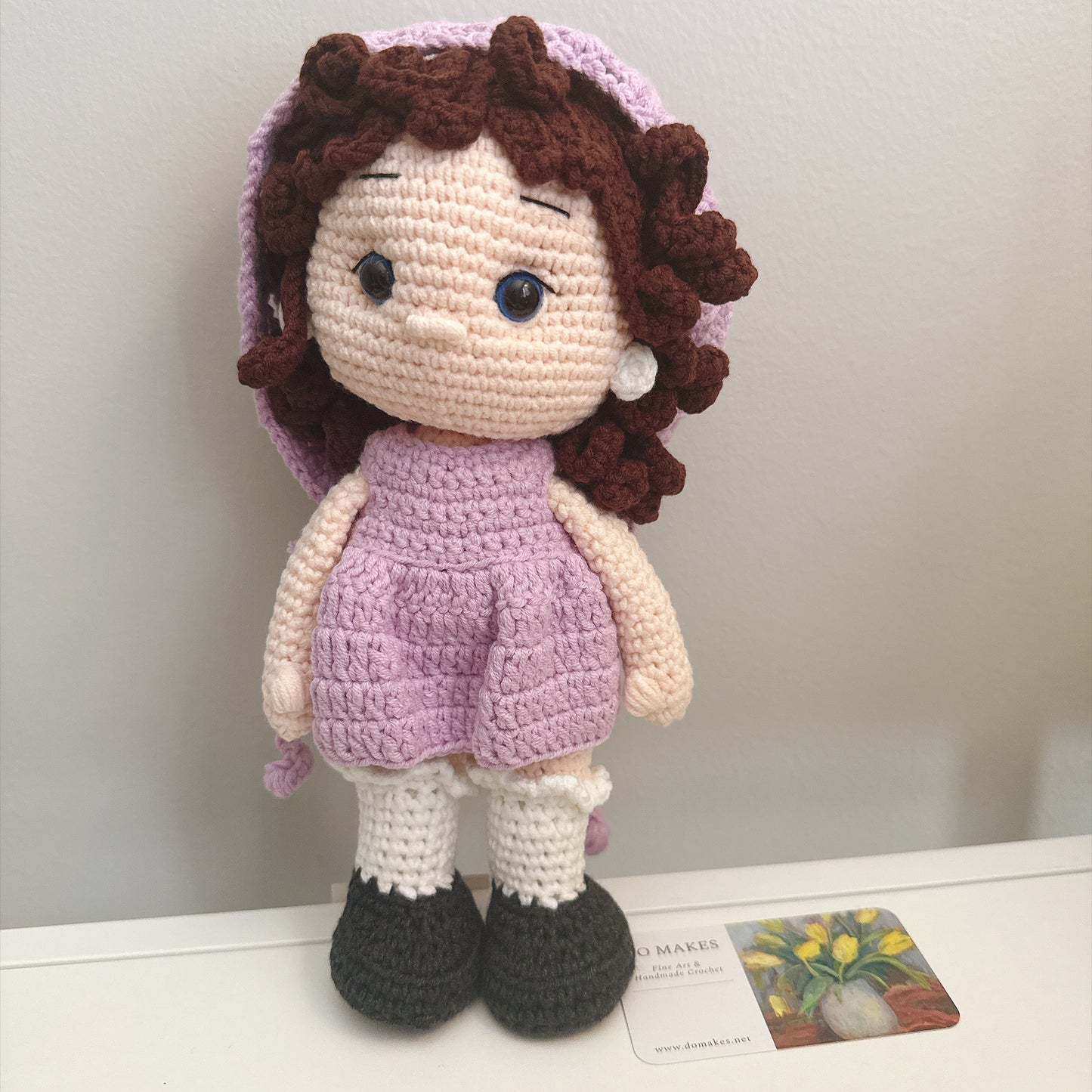 Brown hair doll in purple dress & hat