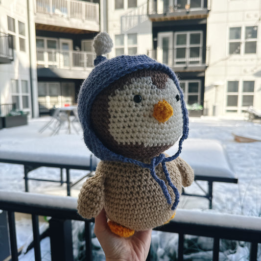 Penguin wearing a blue wool hat