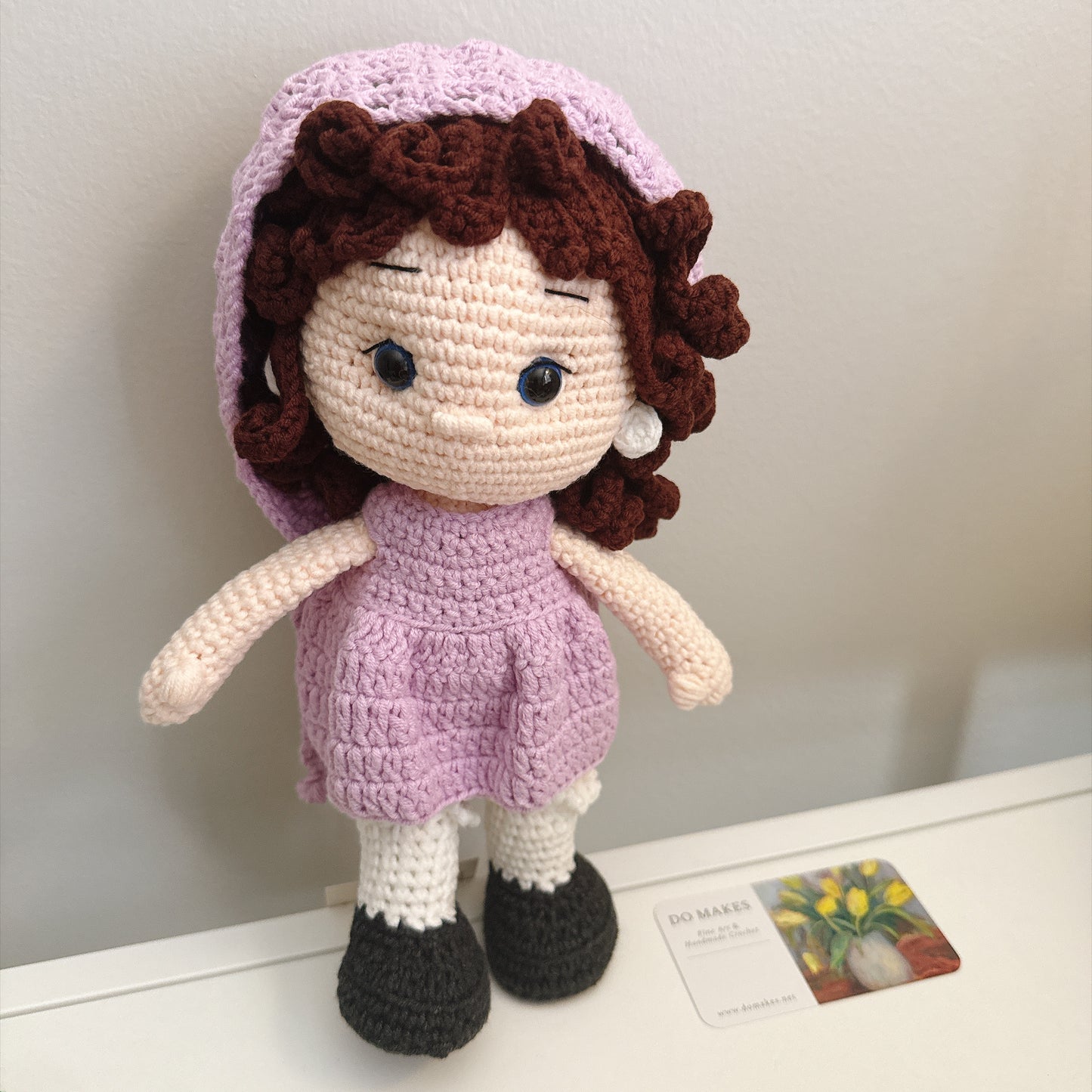 Brown hair doll in purple dress & hat